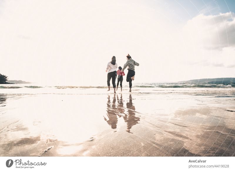 Happy women friends runs at sea beach during a bright day, friends happy relax having fun playing on beach near sea when sunset in evening. friendship party