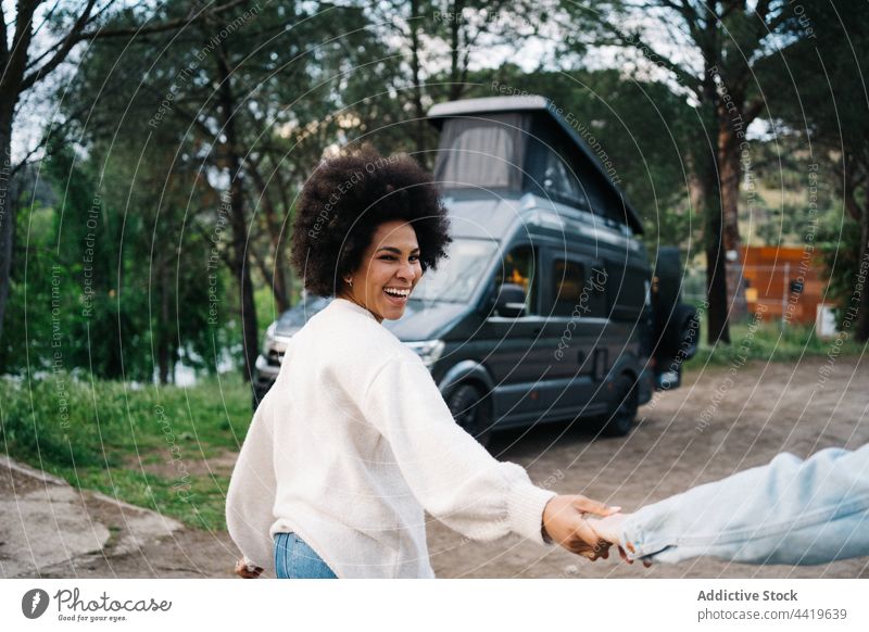 Multiethnic couple holding hands while walking against caravan in camp camper smile spend time weekend romantic summer natural together african american black