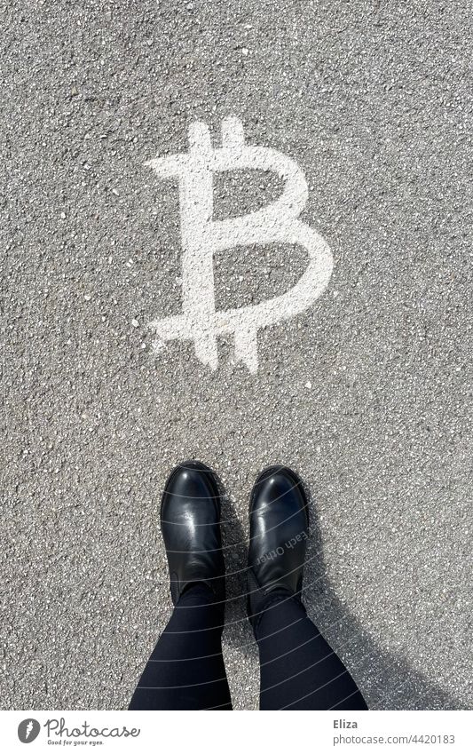 A person stands in front of a Bitcoin symbol - cryptocurrency, finance, money bit coin crypto currency Money Investment investment