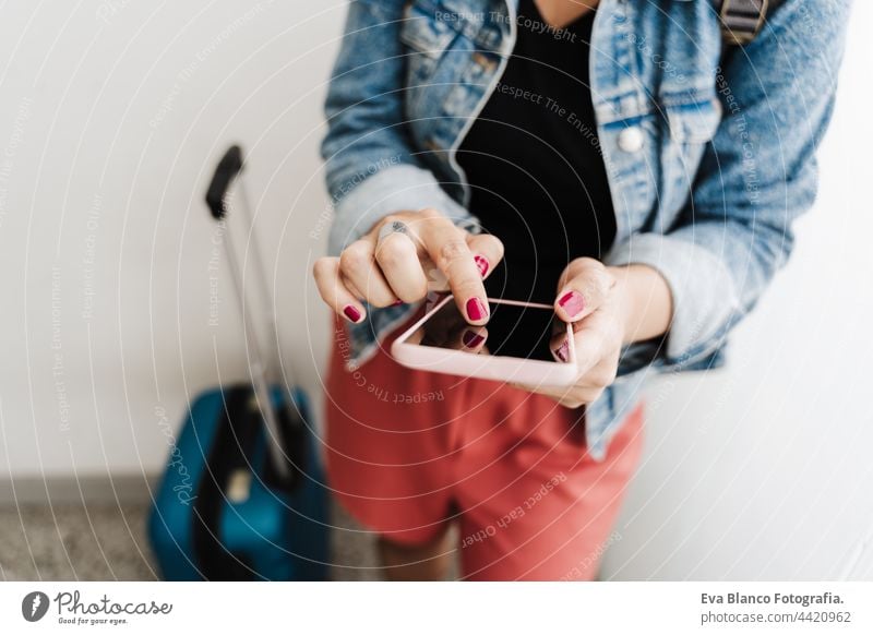 close up of backpacker caucasian woman at train station using smart phone app while waiting. Travel concept unrecognizable mobile phone travel technology