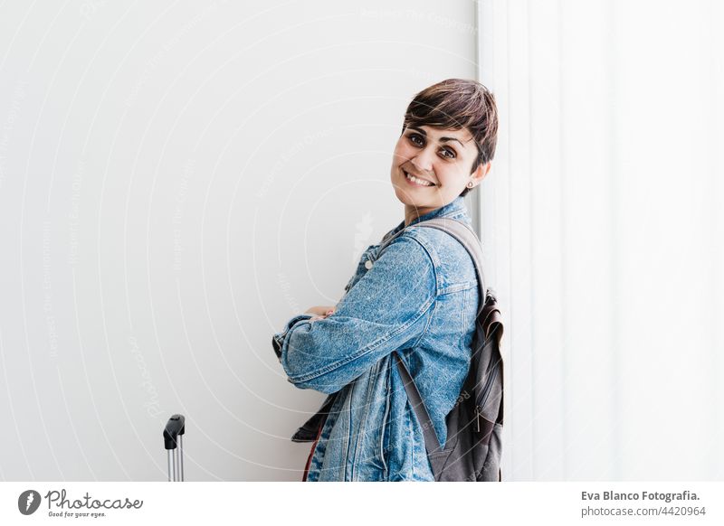 smiling caucasian woman at train station waiting to catch train. Travel concept travel public transport young suitcase luggage baggage happy backpack backpacker