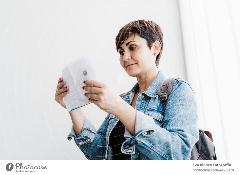 beautiful backpacker caucasian woman at train station holding ticket waiting to catch train. Travel concept travel public transport young suitcase luggage