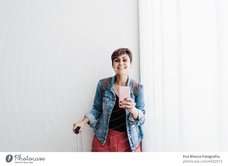 happy backpacker caucasian woman at train station using mobile phone app while waiting. Travel concept travel technology baggage internet online smart phone