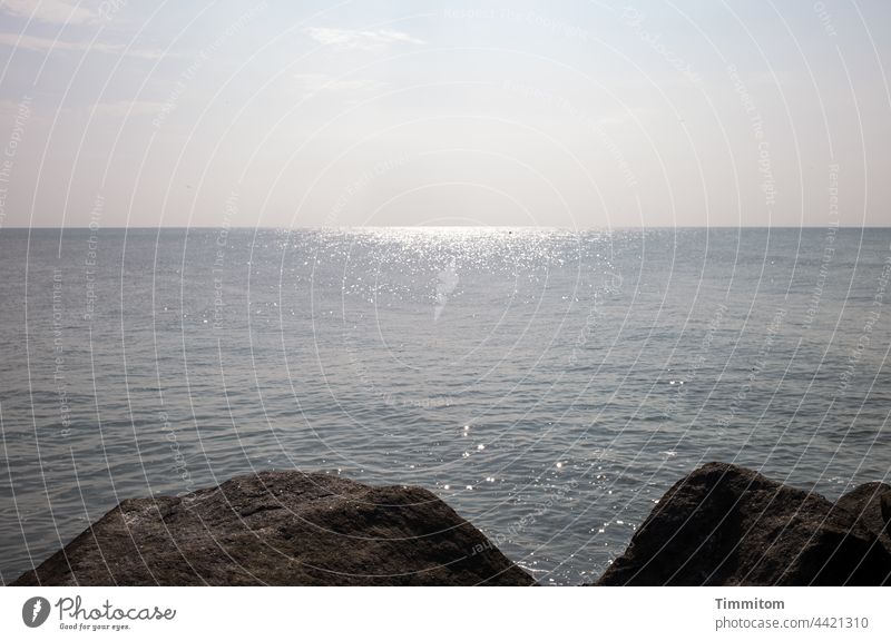 Stones of a pier, shining North Sea and soft sky Mole stones Fastening Dam Water Calm Glittering Horizon Sky Smooth Light Ocean Exterior shot Deserted