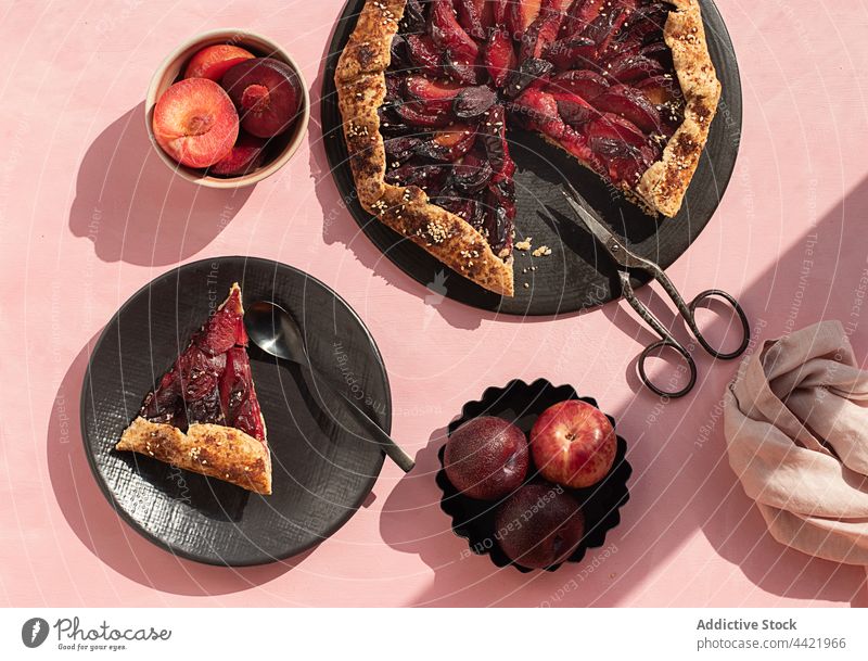 Closeup of a plum cake seen from above plate bakery knife pastries plums cooking close up sweet pastries no people tart - dessert fruit tart pink background