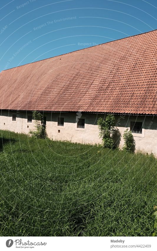 Big stables of an old farmstead in front of a blue sky in sunshine at Brake Castle in Lemgo near Detmold in East Westphalia-Lippe Barn Farm Estate Building Roof