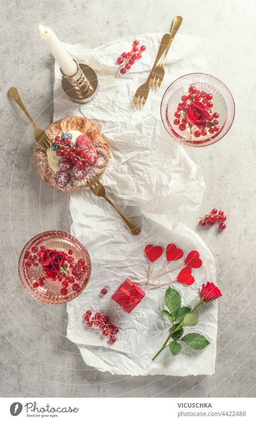 Cocktail glasses mit Champagne , cake and many red heart with rose flowers. Top view. Romantic breakfast cocktail champagne top view romantic strawberry