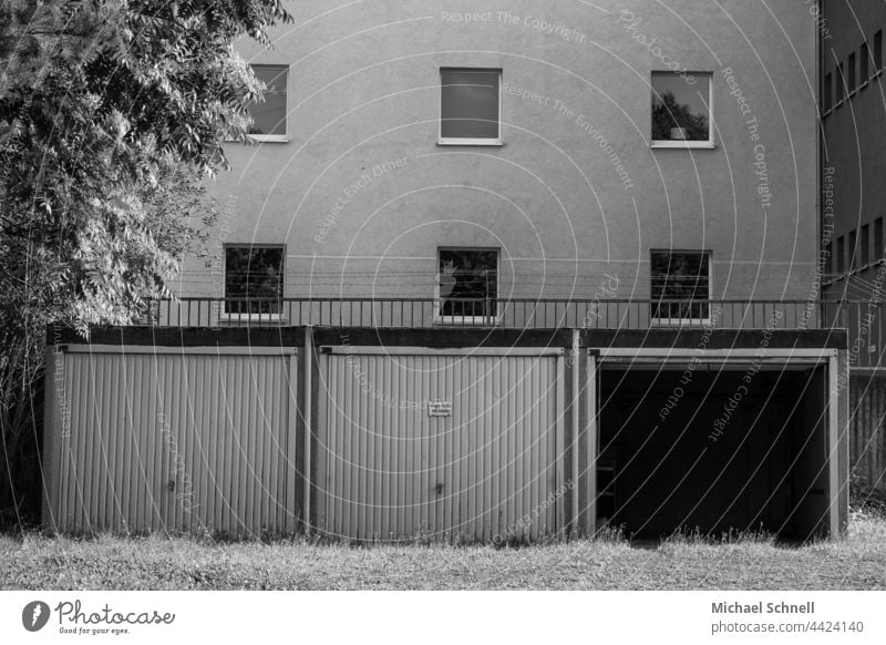 Three garages in a residential area, one of them is open Open Garage Garage door Garage doors Closed Highway ramp (entrance) Gloomy Exterior shot Architecture