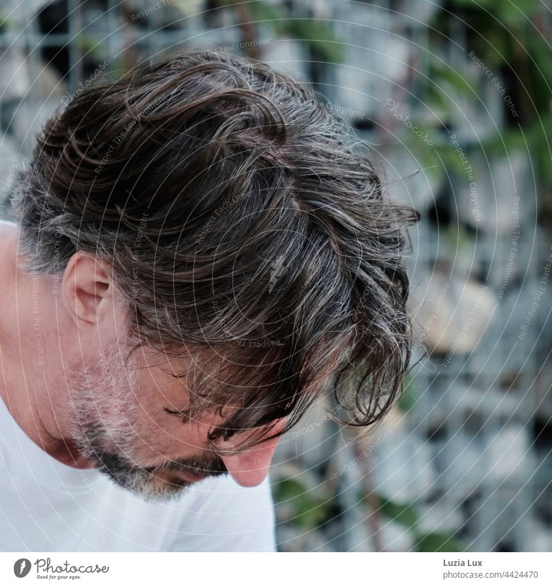 Man looks down, his curls fall over his forehead and his eyes portrait Curl Face Human being Masculine Head Downward thoughts Colour photo Disheveled Meditative