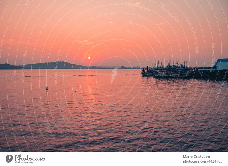 Scenic view of Khmer fishing boats in the harbor of Koh Sdach Island in Cambodia during sunset koh sdach island cambodia khmer fishing boats pink sunset sparse