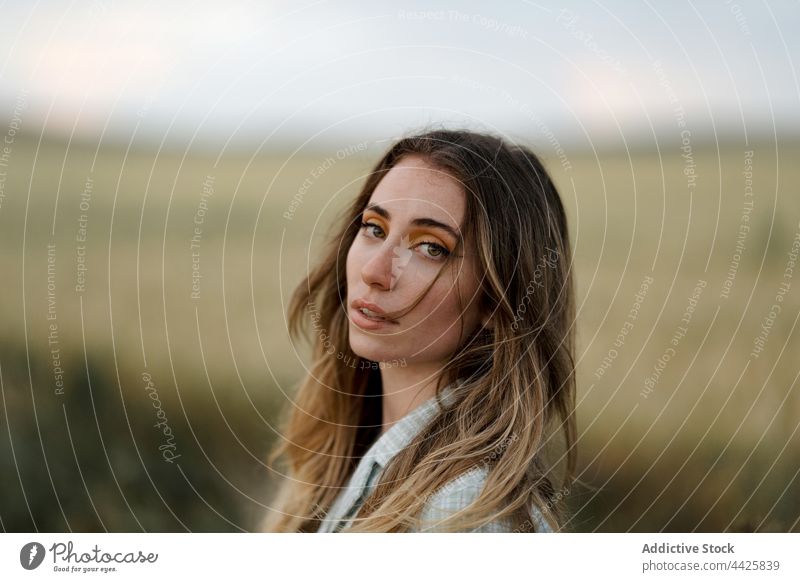 Stylish model in field under cloudy sky mindfulness style nature woman countryside dreamy concentrate atmosphere meadow vegetate grow reflective cereal