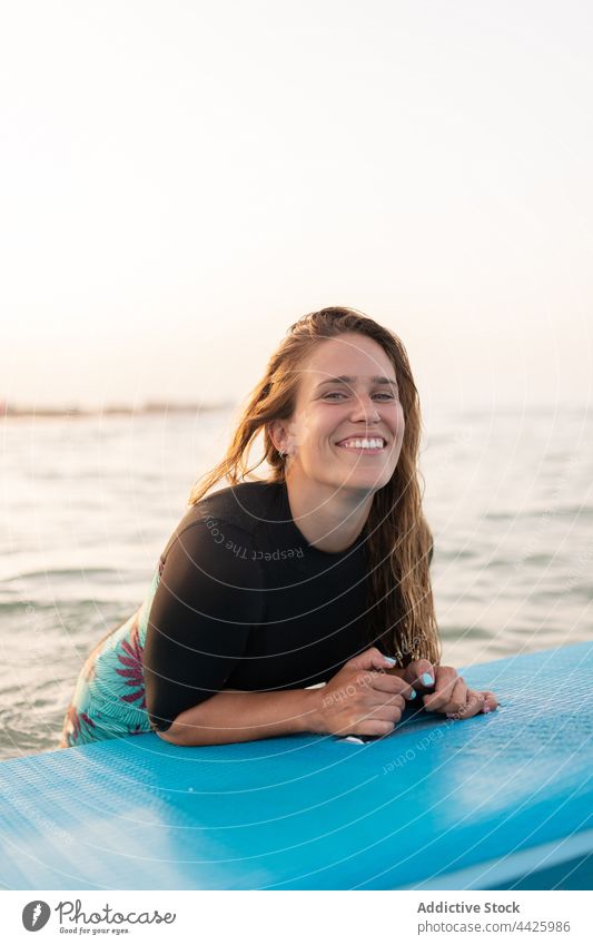 Cheerful woman swimming on paddleboard in sea surfer sup board float surfboard summer female water lying swimwear enjoy swimsuit ocean vacation smile recreation