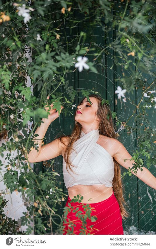 Serene woman smelling flower in garden patio aroma scent fragrant sniff enjoy grace female natural harmony fresh summer gentle calm flora style bloom idyllic