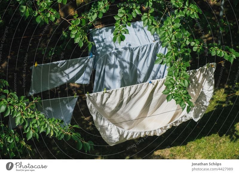 Bed linen drying on the clothesline outside in the garden Laundry hanging up laundry dry laundry Dry Wind Garden Courtyard Backyard Meadow Tree twigs branches