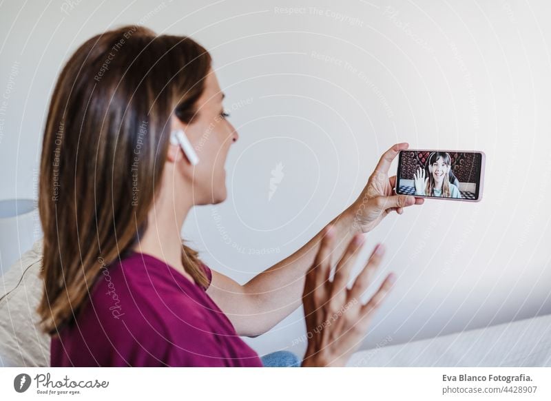 happy caucasian woman at home doing video call with friends on mobile phone. Home office and friendship bed 30s smiling beautiful young conversation digital