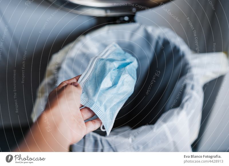 POV of unrecognizable woman hand throwing protective mask into waste at home. Corona virus and recycle concept face mask daytime recycling corona virus covid