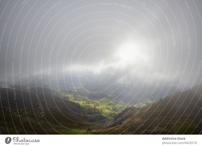 Green mountain valley under clouds hill landscape sunlight green nature scenery highland environment terrain scenic gray thick cloudy weather slope dense