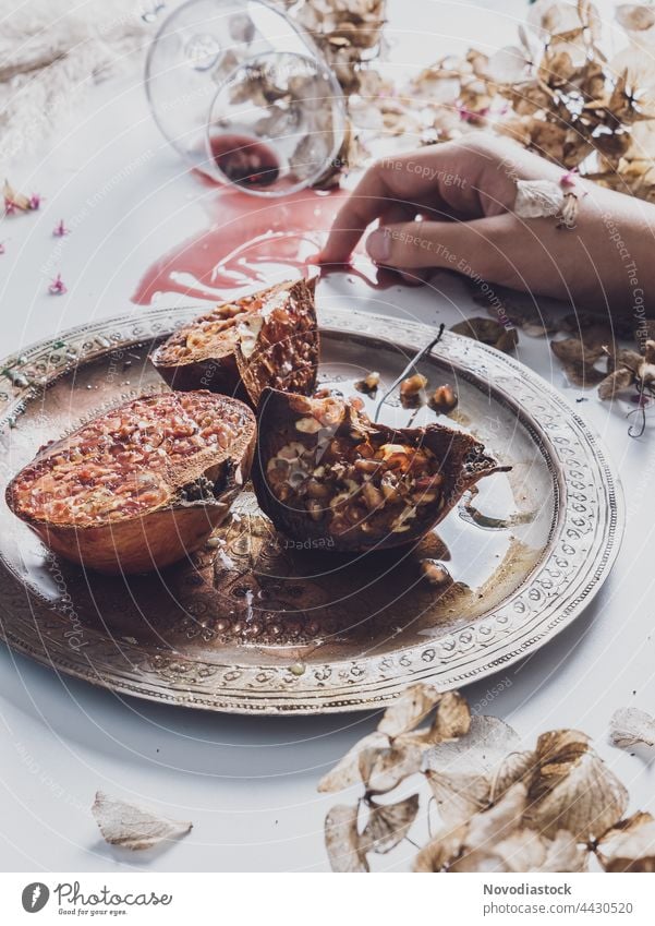 Pomegranates on a plate made of steel, one hand a glass on a table, still life Plate Crockery Colour photo Interior shot Food Hand Table Food photograph