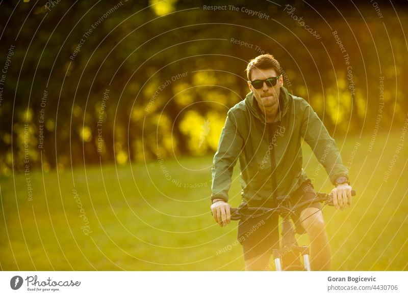 Young man riding ebike in the park active battery bicycle biker biking black cyclist e-bike eco ecologic ecology electric electro energy engine equipment