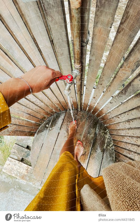 A woman washes the sand off her feet at a beach shower Beach shower Wash vacation Shower Woman Shower (Installation) Water out beach holiday Drops of water Legs