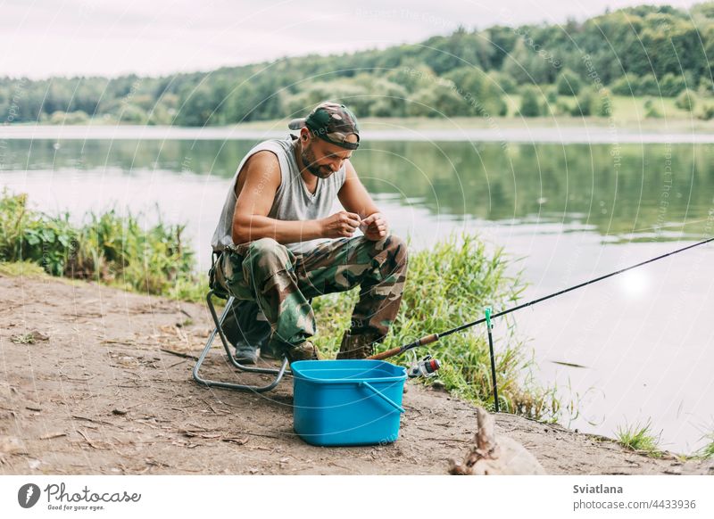 A young fisherman catches fish on a lake or river, prepares tackle and bait. Hobbies, weekends, fishing water adult one sitting chair hunting equipment hand rod