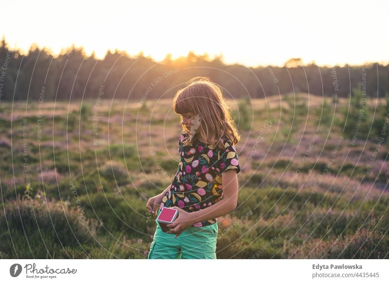 Little girl on a meadow full of heather at sunset grass field rural countryside adventure Wilderness wild
hair vacation travel active summertime day freedom