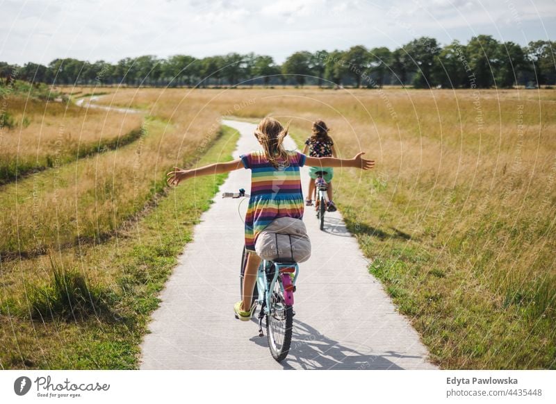 Little girl riding a bicycle with her arms outstretched safe safety Netherlands bike cycling riding bike cycle routes vacation travel active adventure