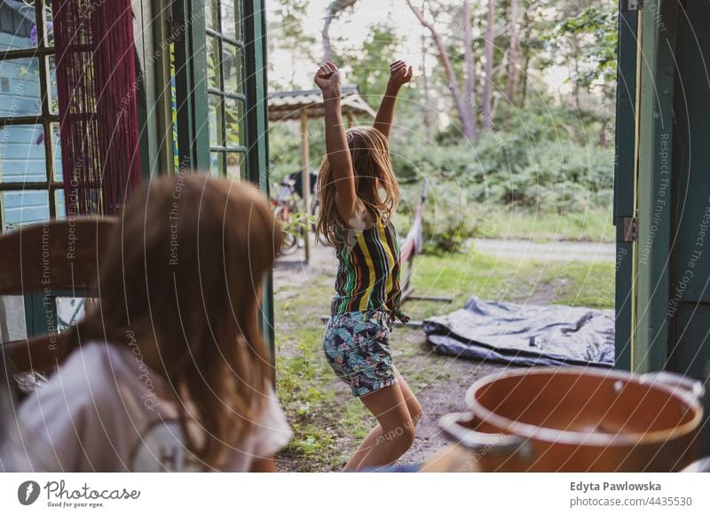 Children playing in the summerhouse cottage home backyard garden dancing playful joy children family cute girl little happy kid childhood fun happiness