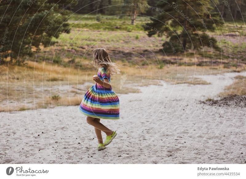 Little girl dancing in nature meadow grass field rural countryside adventure Wilderness wild
hair vacation travel active summertime day freedom holiday enjoying