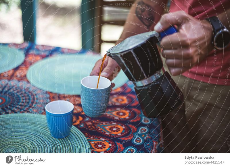 Man pouring coffee from a coffee maker into a cup coffee cup hands drink food fresh freshness barista making home house domestic hipster cafe beverage mug hot