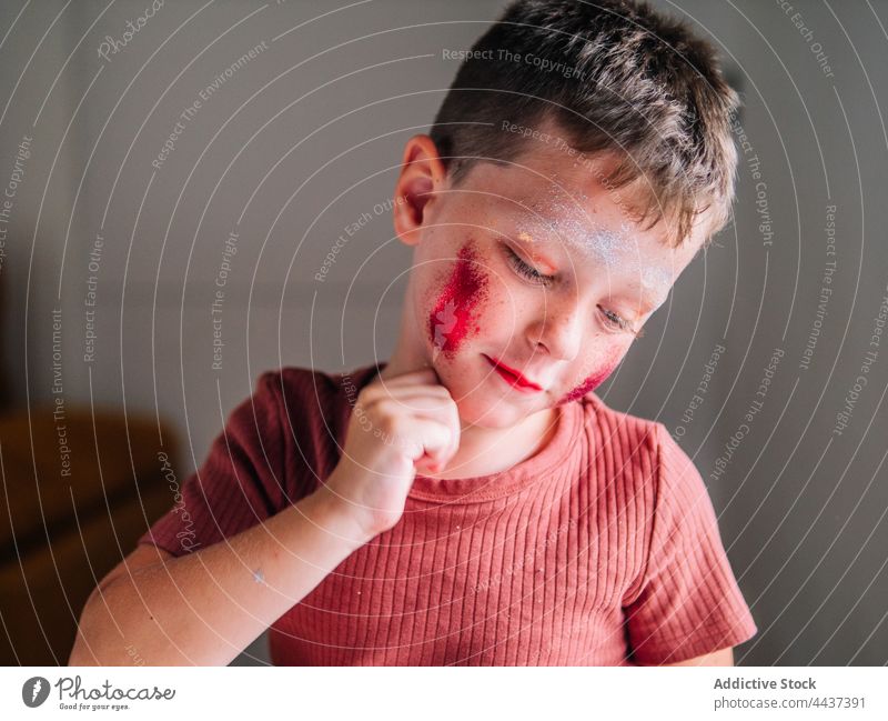 Dirty boy with makeup on cheeks at home messy cosmetic beauty dirty focus childhood red lips house decorative attentive spare time weekend concentrate color