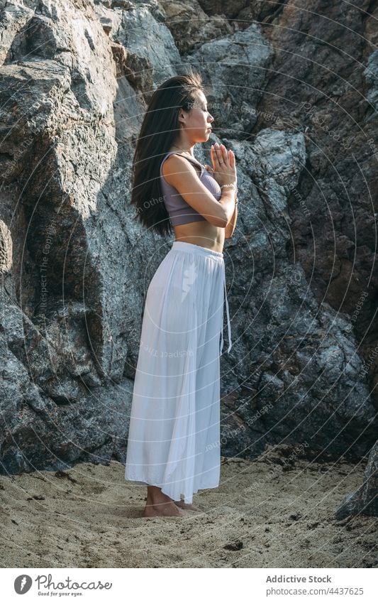 Asian woman meditating with namaste hands against mount yoga meditate spirit energy wellness vitality practice rock mindfulness asana healthy lifestyle breathe