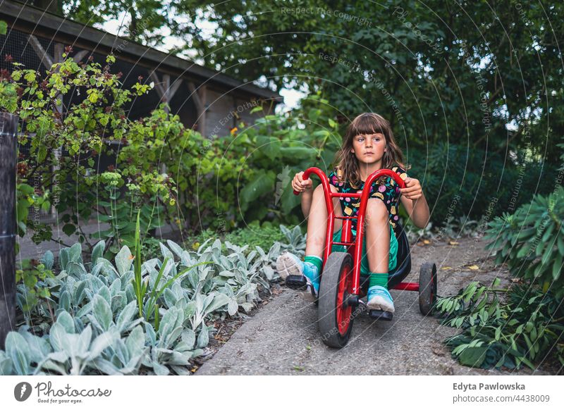 Little girl riding a bike in the park cycling riding bike garden vacation active adventure summertime day freedom holiday enjoying outside serious outdoors