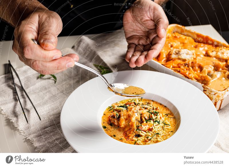 Authentic Spanish paella with cod and mussels. Traditional Mediterranean seafood dish. The chef prepares the dish. Restaurant dish serving. Close-up. People at work. Body parts