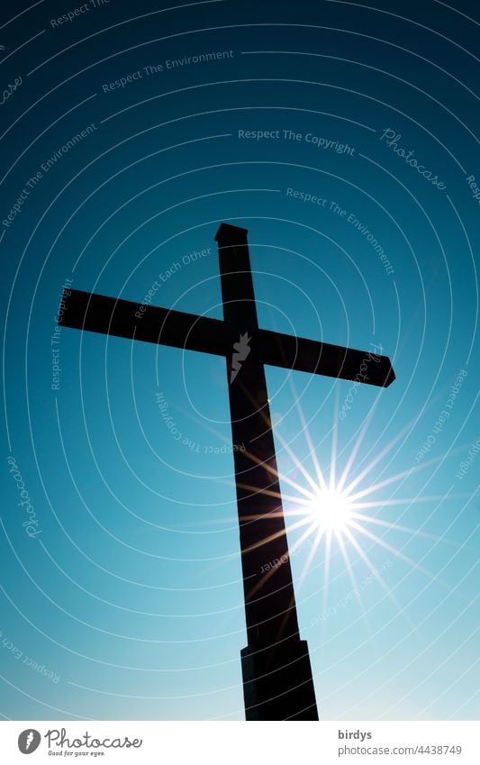 Christian cross with shining sun in front of cloudless blue sky Crucifix Sunbeam Cloudless sky Christianity Religion and faith Symbols and metaphors Church Hope