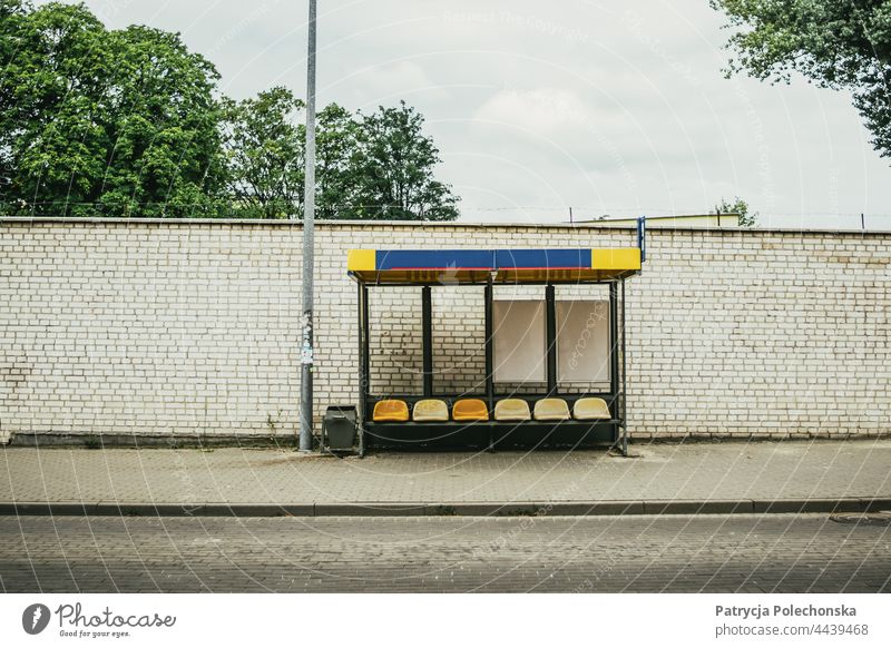 Empty bus stop in front of a grey brick wall by the street Bus stop Public transit PUBLIC TRANSPORT Wall (building) Brick City transportation Street Old