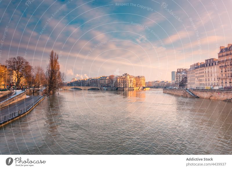 Old architecture on coast of river under bright sky district cityscape shore winter bridge historic old building dwell river bank tree embankment residential