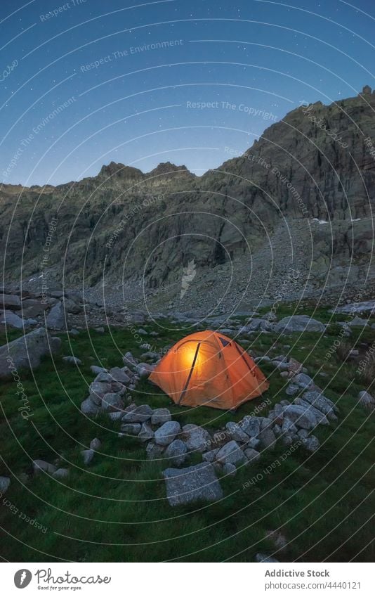 Tent against rough mountain under blue sky in evening tent highland nature landscape geology hike tourism twilight ridge camp rugged dry barren immense bristly