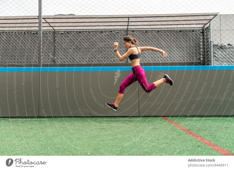 Active woman jumping high during workout in stadium training dynamic leap power fitness active female sportswoman energy above ground move healthy lifestyle