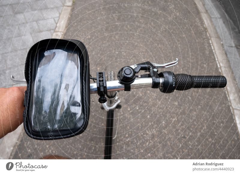 Cyclist on the bike path. First person view. Focus on the hand and the handlebars. cyclist mobile phone pov first person city ride summer road lifestyle traffic