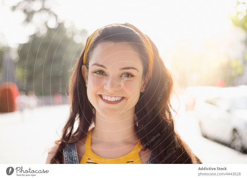 Charming woman standing on street charming personality style cool millennial posture appearance female feminine individuality brunette carefree denim gaze