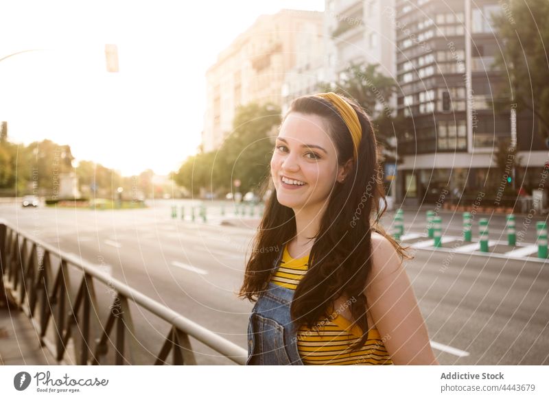 Charming woman standing on street charming personality style cool millennial posture appearance female feminine individuality brunette carefree denim gaze