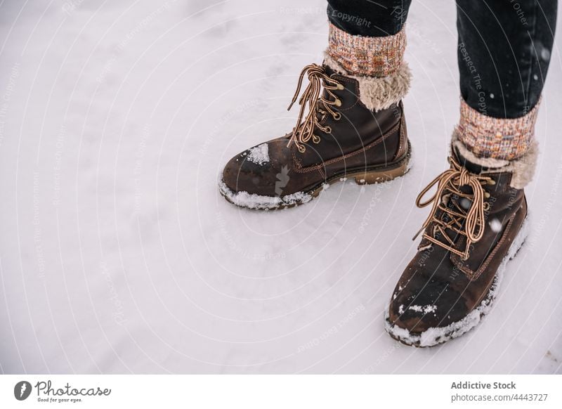 Person in warm socks and boots standing on snowy ground person cold winter weather season footwear frost leg nature frozen casual wintertime daytime shoe