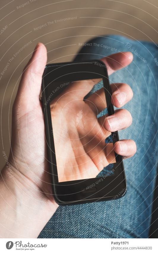 Close-up of a hand holding a smartphone, on the display of which the hand holding it can be seen translucent Cellphone Hand stop Translucent Lifestyle Telephone