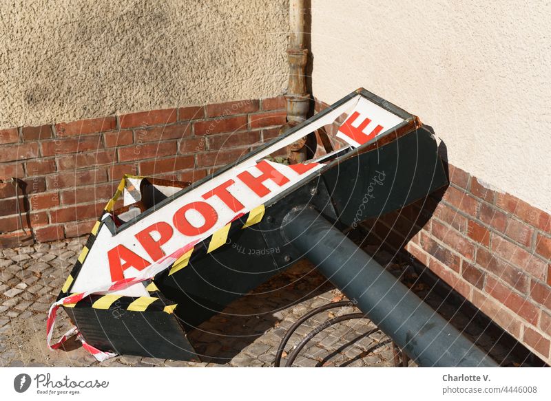 Pharmacy deaths Pharmacy sign Arrow Broken lettering corrupted Destruction shattered Transience Decline Past Security tape Wall (barrier) Change fallen