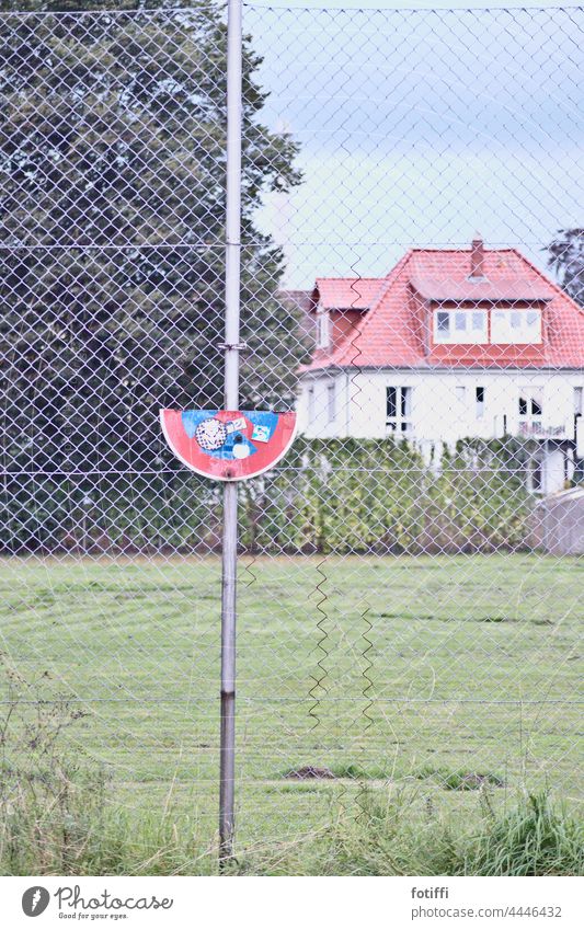 lying sign crescent in front of red roofed house Signs and labeling Characters Deserted Exterior shot Clearway Parking no parking Transport Road sign