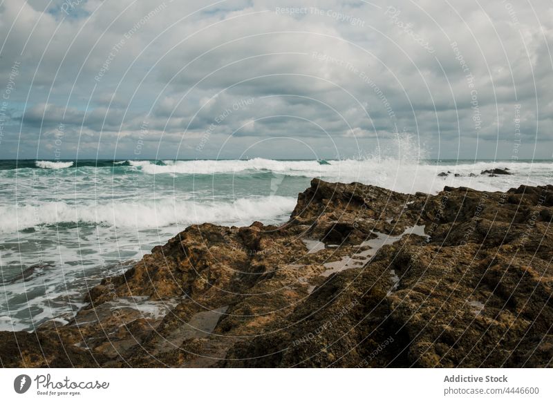 Stormy ocean against rocky coast under cloudy sky sea stormy motion foamy flow highland nature energy dynamic mount landscape fast fluid seashore rough barren