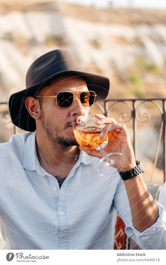 Stylish man drinking Aperol Spritz in bar aperol spritz cocktail style cool alcohol cold chill male beverage relax beard young sunglasses terrace trendy booze