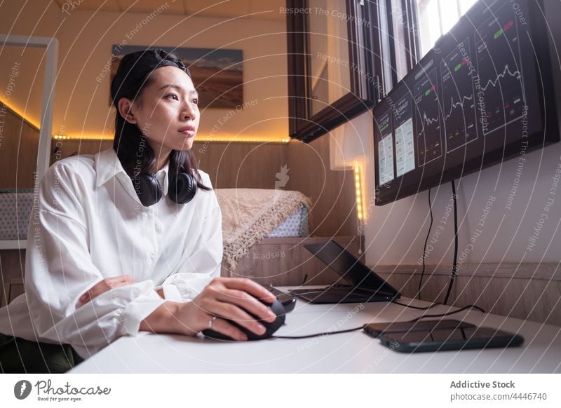 Serious ethnic female trader analyzing cryptocurrency market statistics woman analyze data using monitor diagram workplace finance internet busy economy