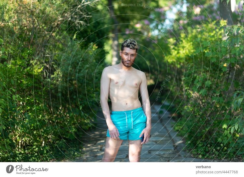 shirtless caucasian young man wearing turquoise shorts in a park in summer dancer gay happy lifestyle person dancing pride background identity male lgbtq people